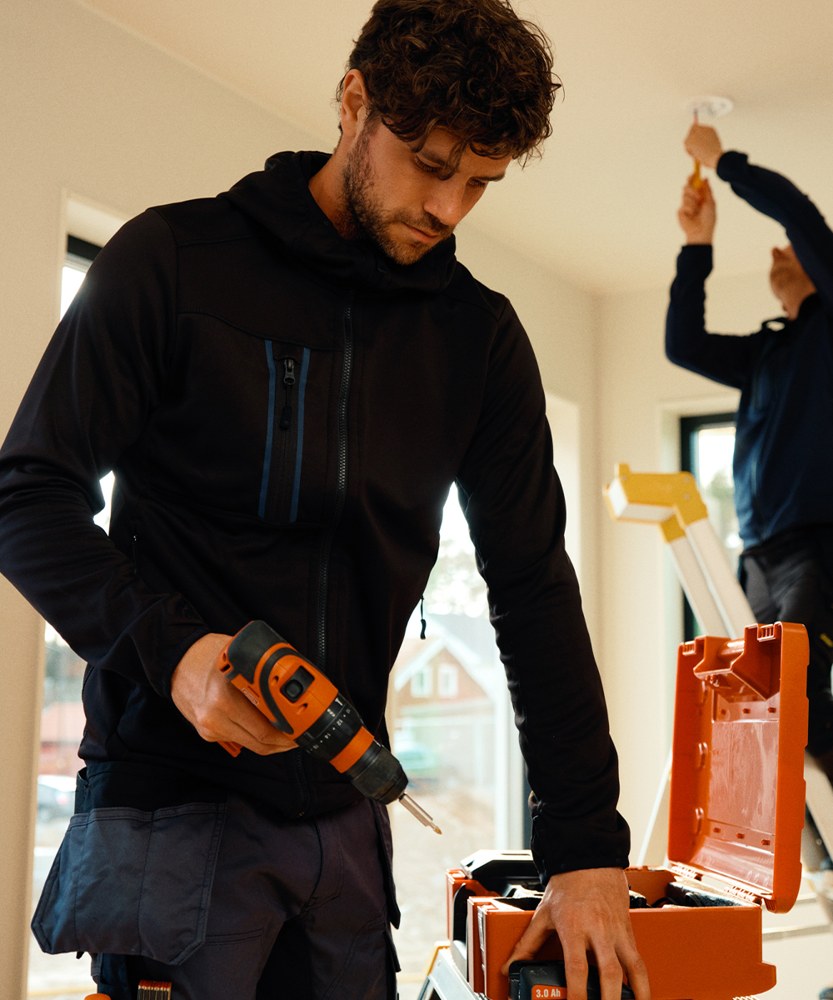 Artisan en sweat à capuche dans son atelier